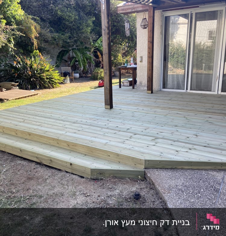 דק עץ חדש עם מדרגות בגינה